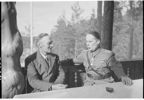 Kenraaliluutnantti W.E.Tuompon 50-vuotispäivä. Päivän sankari Rajavartiolaitoksen henkilökunnalta saamansa kesämajan viihtyisällä verannalla luovutustilaisuudessa.