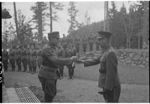 Kenraaliluutnantti W.E.Tuompon 50-vuotispäivä. Eversti Villamo ojentaa Rajavartiolaitoksen henkilökunnan lahjoittaman kesämajan avaimet uudelle isännälle, kenraaliluutnantti Tuompolle.