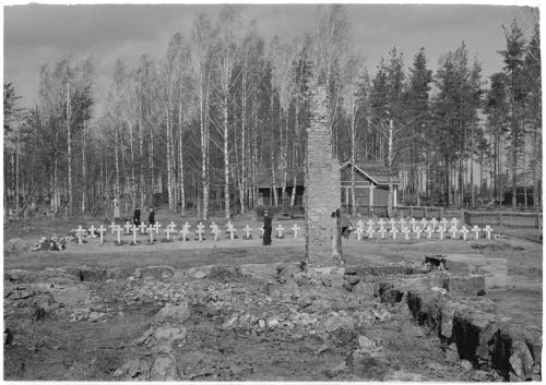 Kirkon rauniot, taustalla sankarihaudat.