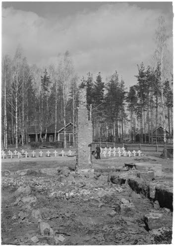 Kirkon rauniot, taustalla sankarihaudat.