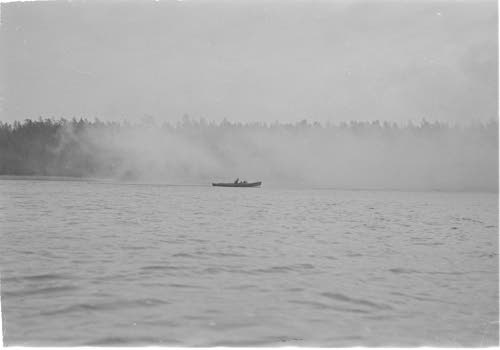 Iskujoukkueen maihinnousua vihollisen hallussa olevaan saareen savuverhon suojassa, kasapanoksia heitetään, räjähdyksiä.