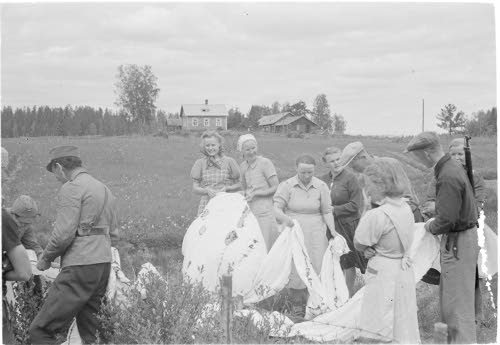 Siviiliväkeä tutkimassa laskuvarjon jäännöksiä