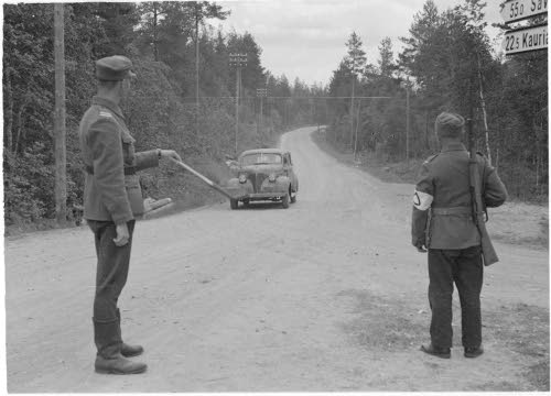 Maantiepoliisit tarkastavat kulkulupia.