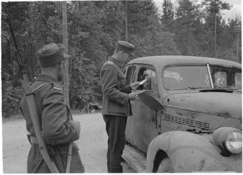 Maantiepoliisit tarkastavat kulkulupia.