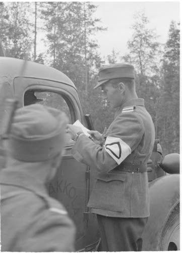 Maantiepoliisit tarkastavat kulkulupia.