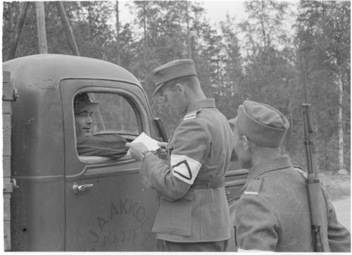 Maantiepoliisit tarkastavat kulkulupia.